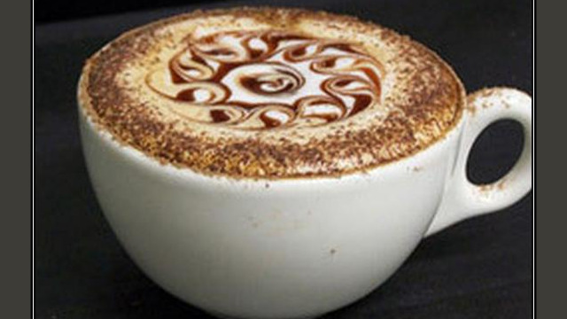Arte del café con leche: diseño floral dibujado en la espuma Arte del café con leche: diseño floral dibujado en la espuma