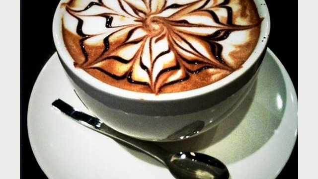 Arte del café con leche: diseño floral, dibujado en la espuma Arte del café con leche: diseño floral, dibujado en la espuma