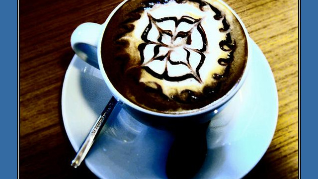 Arte del café con leche: flor dibujada en la espuma,contraste Arte del café con leche: flor dibujada en la espuma, contraste