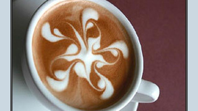 Arte del café con leche: motivo floral dibujado en la espuma Arte del café con leche: motivo floral dibujado en la espuma