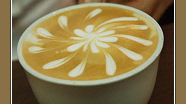Arte del café con leche: flor con pétalos, dibujada en la espuma Arte del café con leche: flor con pétalos, dibujada en la espuma